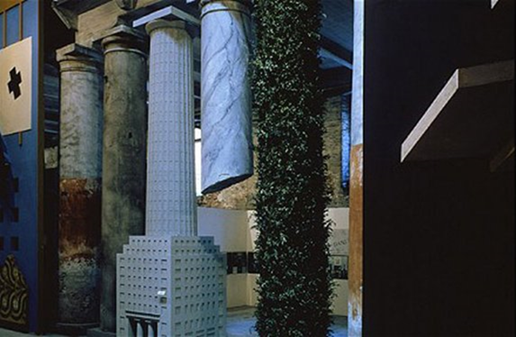 2012 yılında Londra’da Victoria & Albert Museum’da açılan “Postmodernism: Style and Subversion 1970 – 1990” adlı sergiden bir Hans Hollein (1934-2014) tasarımı. Sergide, 1970’lerin başında mimari ile sahneye çıkan Postmodernizm’in sanatın tüm dallarını nasıl hızla etkisi altına aldığını göstermek amaçlanmıştı. Çılgın renk kullanımı, suni görünümlü yüzeyler, tarihsel göndermeler, zeki espriler ile sınır tanımayan bir tasarım özgürlüğünün sinemaya, müziğe, grafik sanatlara, modaya nasıl hakim olduğu sergilenmişti. Serginin ana parçası, fotoğraftaki, 1980 Venedik Mimarlık Bienali için hazırlanmış olan parçaydı. Fotoğraf:www.acflondon.org-